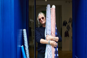 Charlotte Bialas holding fabrics and wearing Maggie sunglasses from Oscar Magnuson outside her store in Paris